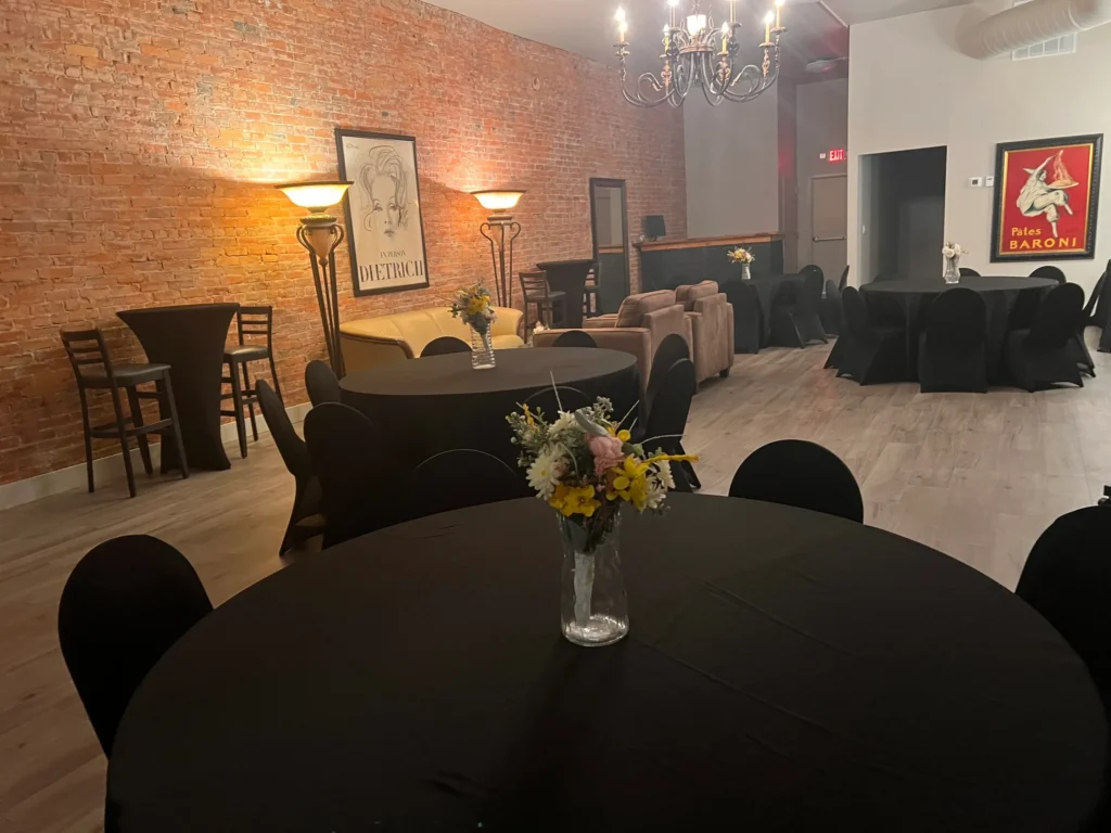 Cocktail rounds in black linen with fresh flowers, set for a reception